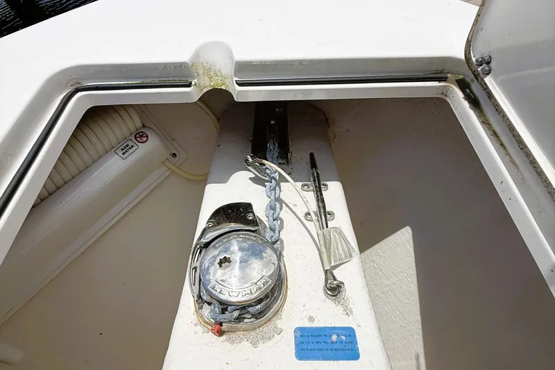 Slide: The Image of Anchor compartment of 2021 Cobia 280 Center Console boat, featuring chain and winch. - 10