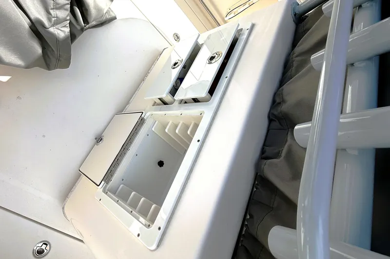 Slide: The Image of 2021 Cobia 280 Center Console boat interior with storage compartments and rod holders. - 11