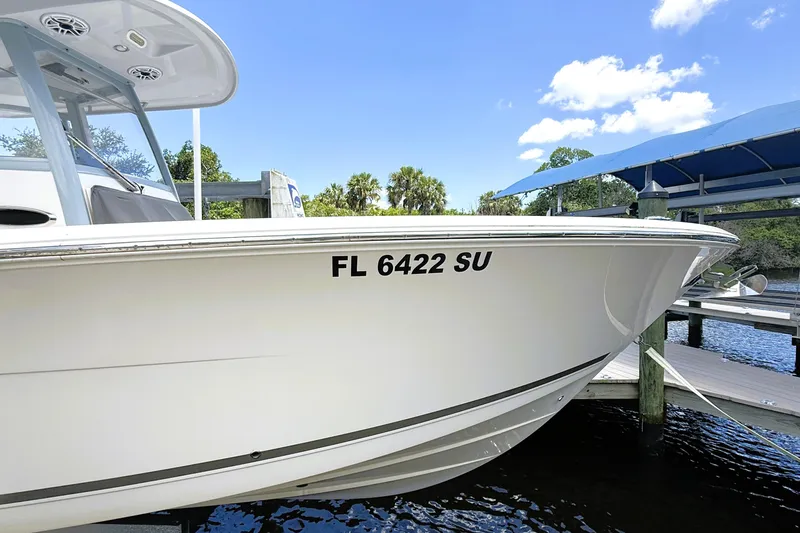 Slide: The Image of 2021 Cobia 280 Center Console boat docked, displaying registration FL 6422 SU. - 18