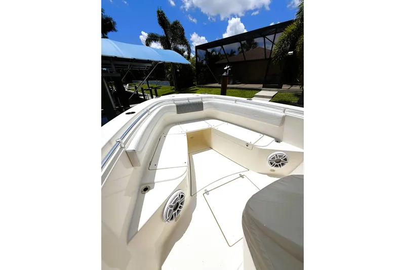 Slide: The Image of 2021 Cobia 280 Center Console boat interior with seating and speakers, under a sunny sky. - 9