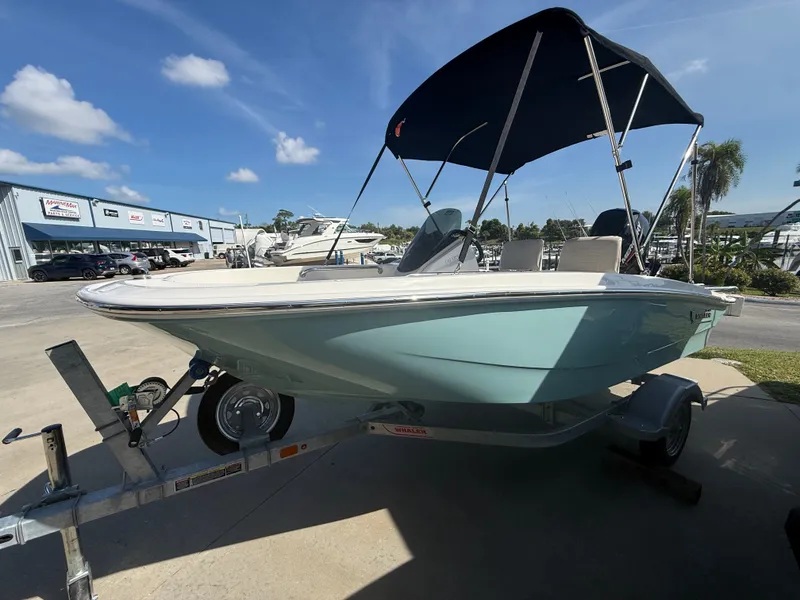 Slide: The Image of A 2027 Boston Whaler 130 Super Sport on a trailer with a blue Bimini top. - 3