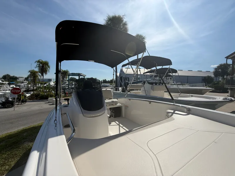 Slide: The Image of The image shows a 2027 Boston Whaler 130 Super Sport boat with a sunshade, docked at a marina. - 6