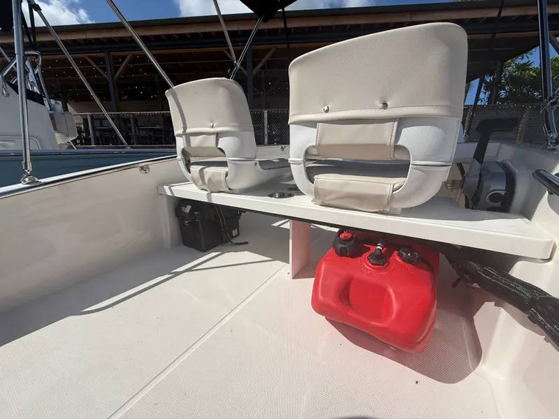 Slide: The Image of The image shows the interior of a 2027 Boston Whaler 130 Super Sport with two seats and a red fuel can. - 13