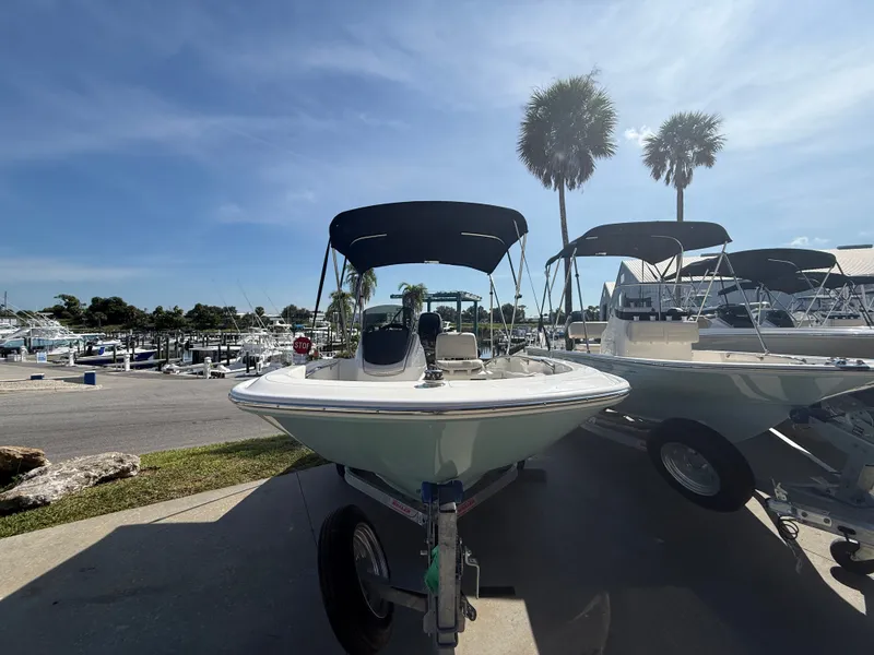 Slide: The Image of A 2027 Boston Whaler 130 Super Sport on a trailer in a sunny marina. - 2