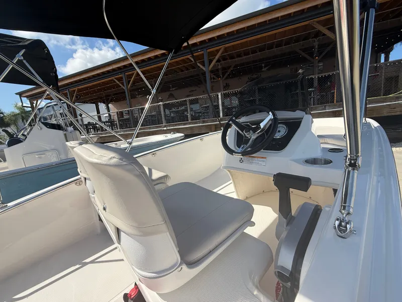 Slide: The Image of The image shows the cockpit of a 2027 Boston Whaler 130 Super Sport with a white seat and steering wheel. - 10
