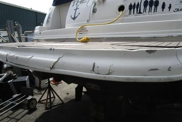 Slide: The Image of 2006 Sea Ray Sundancer 320 with visible hull damage in a boatyard setting. - 4