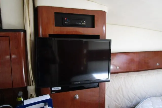 Slide: The Image of 2006 Sea Ray Sundancer 320 interior with mounted TV and wooden cabinetry. - 15