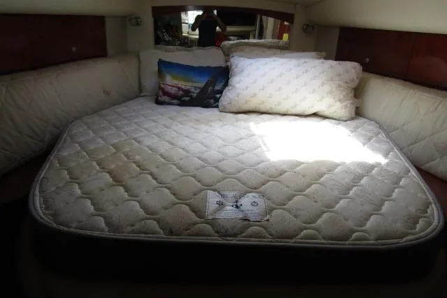 Slide: The Image of 2006 Sea Ray Sundancer 320 cabin with a cozy bed and decorative pillows. - 14