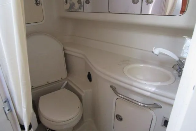 Slide: The Image of 2006 Sea Ray Sundancer 320 bathroom with toilet, sink, and storage cabinets. - 13
