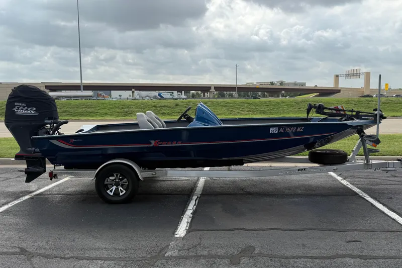 The Image of 2018 Xpress X19 Pro boat on trailer, parked in a lot under cloudy skies. - 1