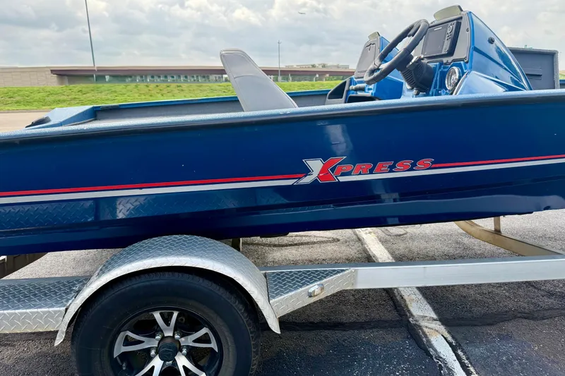Slide: The Image of Blue 2018 Xpress X19 Pro boat on trailer, parked outdoors. - 9