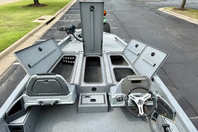 Slide: The Image of 2018 Xpress X21 Pro boat interior with open storage compartments and steering wheel. - 14