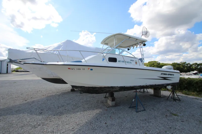 The Image of 2002 Hydra-Sports 230 WA boat on stands, under a partly cloudy sky. - 0