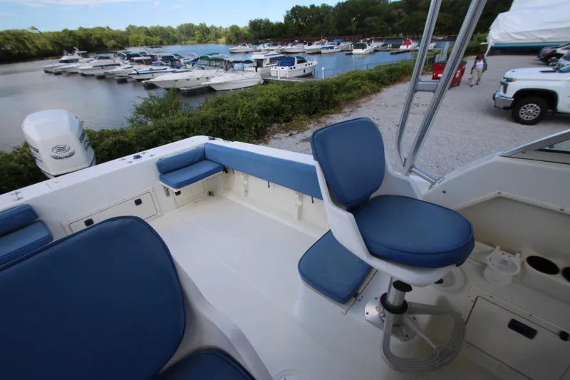 Slide: The Image of 2002 Hydra-Sports 230 WA boat interior with blue seating, docked near a marina. - 10