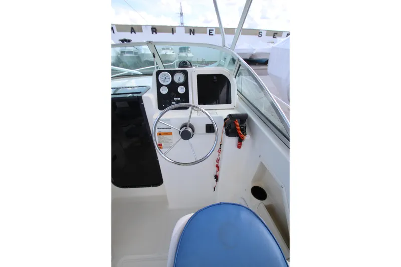 Slide: The Image of 2002 Hydra-Sports 230 WA boat cockpit with steering wheel and instrument panel. - 13