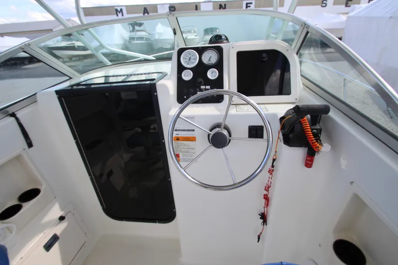 Slide: The Image of 2002 Hydra-Sports 230 WA boat cockpit with steering wheel and control panel. - 14