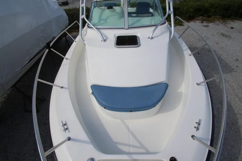 Slide: The Image of 2002 Hydra-Sports 230 WA boat, white deck with blue cushion, docked outdoors. - 18