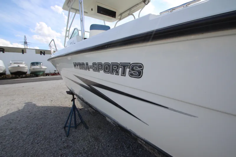 Slide: The Image of 2002 Hydra-Sports 230 WA boat on stand, marina background, clear sky. - 5