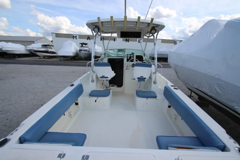 Slide: The Image of 2002 Hydra-Sports 230 WA boat interior with blue seating, docked at a marina. - 7