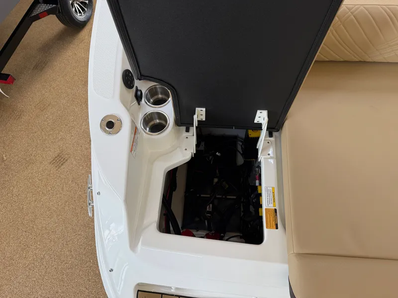 Slide: The Image of An open storage compartment on a Sea Ray SDX 230 boat with cup holders and seat cushions. - 13