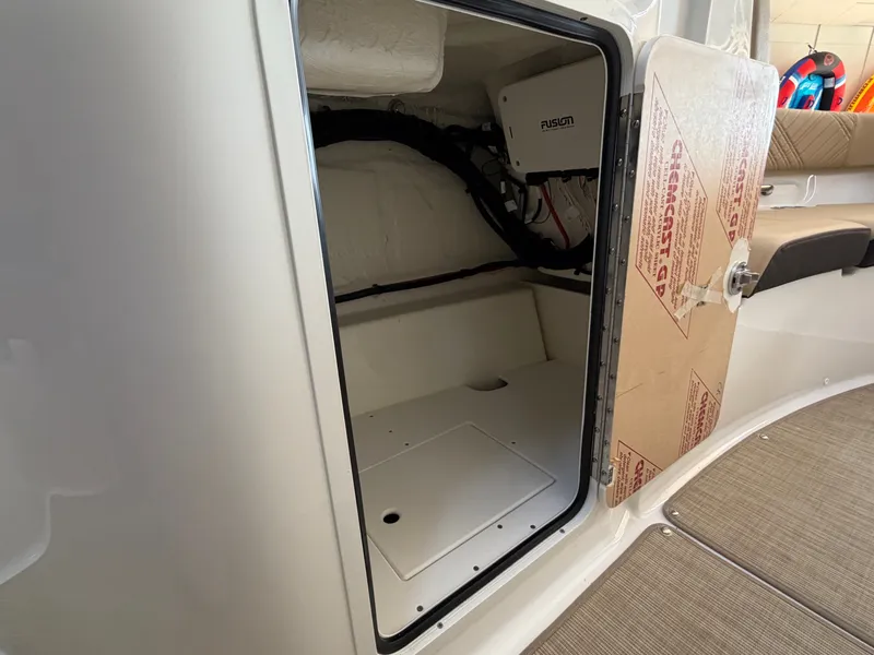 Slide: The Image of An open storage compartment on a Sea Ray SDX 230 boat, featuring a Fusion audio system. - 42