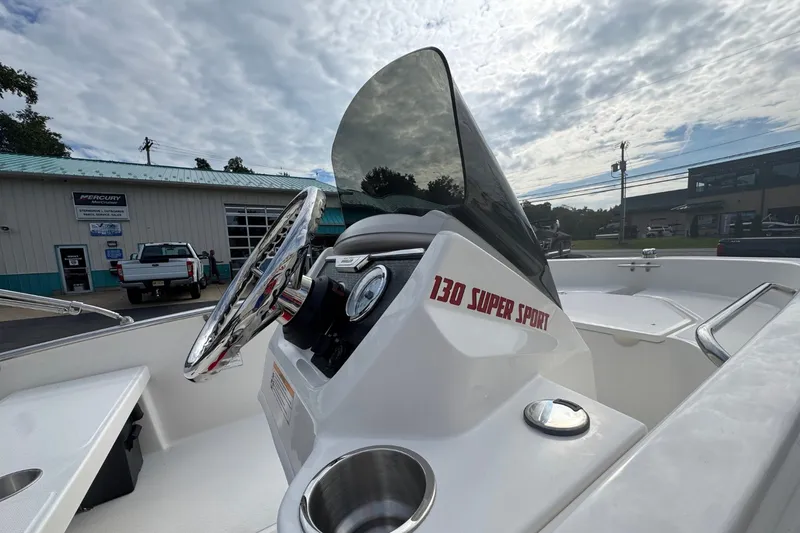Slide: The Image of The image shows the helm of a 2027 Boston Whaler 130 Super Sport with a windshield. - 13