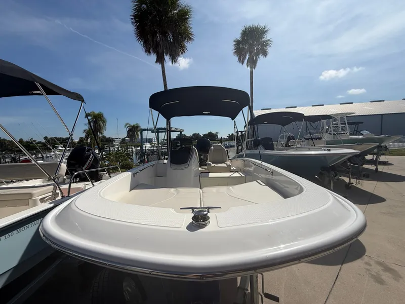 Slide: The Image of A 2027 Boston Whaler 160 Super Sport on a dock. Palm trees and other boats in the background. - 1