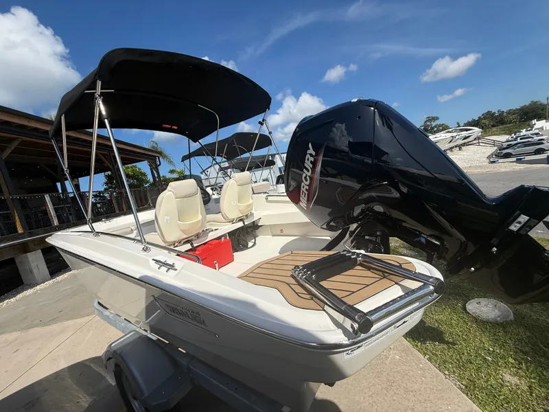 Slide: The Image of A 2027 Boston Whaler 160 Super Sport with a black outboard motor and sunshade. - 4