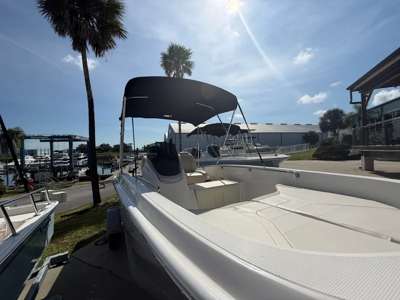 Slide: The Image of A 2027 Boston Whaler 160 Super Sport is on land. It features a sunshade and is parked in a marina. - 6