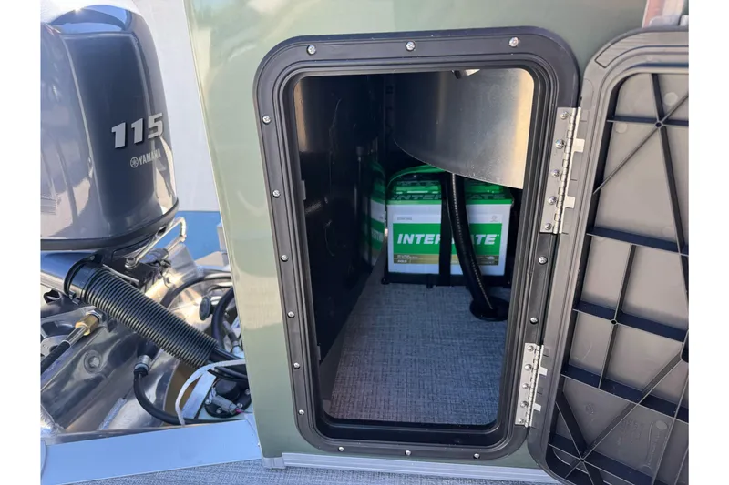 Slide: The Image of Open storage compartment on 2026 Tahoe Pontoon Geofish RF 21, revealing batteries and Yamaha 115 engine. - 16