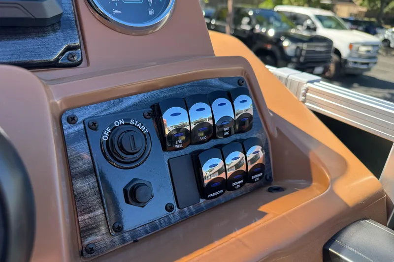 Slide: The Image of Dashboard controls of 2026 Tahoe Pontoon Geofish RF 21 boat, featuring switches and ignition. - 26