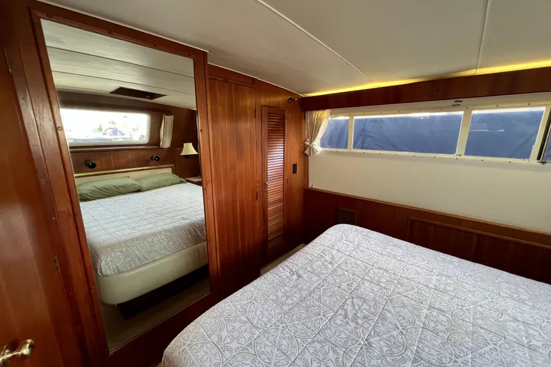 Slide: The Image of Interior of 1985 Tollycraft 48 Cockpit Motor Yacht with wood paneling and cozy bedding. - 100