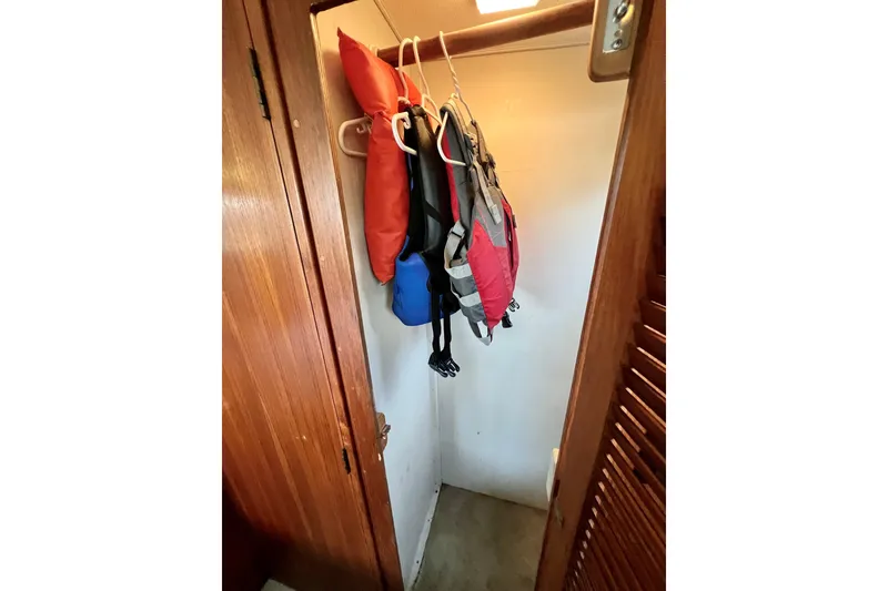 Slide: The Image of Life jackets hanging in a wooden closet on a 1985 Tollycraft 48 Cockpit Motor Yacht. - 103