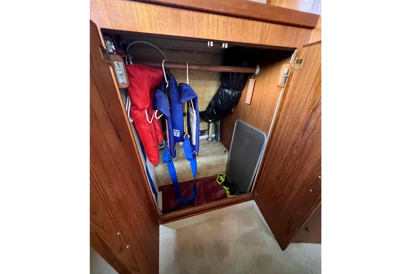 Slide: The Image of Storage cabinet on 1985 Tollycraft 48 Cockpit Motor Yacht with life jackets and equipment. - 104