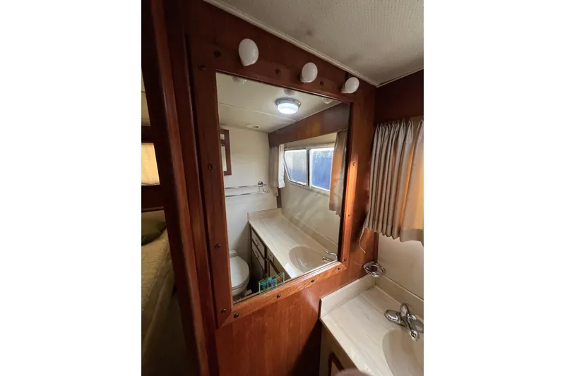 Slide: The Image of 1985 Tollycraft 48 Cockpit Motor Yacht bathroom with mirror, sink, and window. - 108