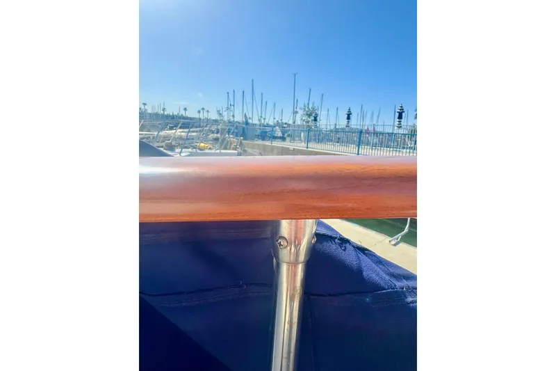 Slide: The Image of 1985 Tollycraft 48 Cockpit Motor Yacht railing with marina background under clear blue sky. - 12