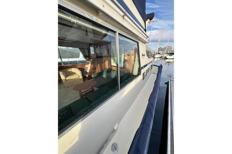 Slide: The Image of 1985 Tollycraft 48 Cockpit Motor Yacht docked, showcasing interior seating and exterior design. - 13