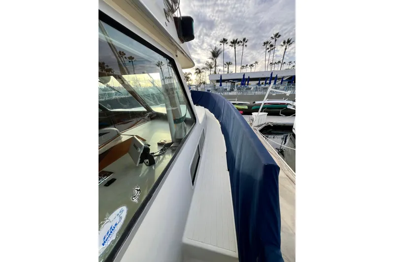 Slide: The Image of 1985 Tollycraft 48 Cockpit Motor Yacht docked, showcasing sleek design and marina view. - 19