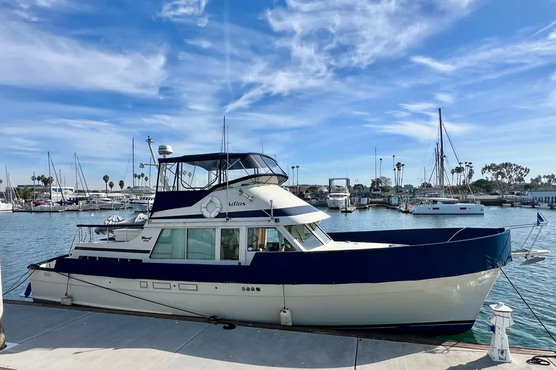 Slide: The Image of 1985 Tollycraft 48 Cockpit Motor Yacht docked at a marina under a clear blue sky. - 2