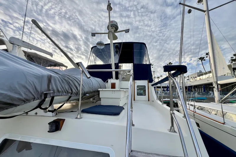 Slide: The Image of 1985 Tollycraft 48 Cockpit Motor Yacht docked under a cloudy sky. - 20