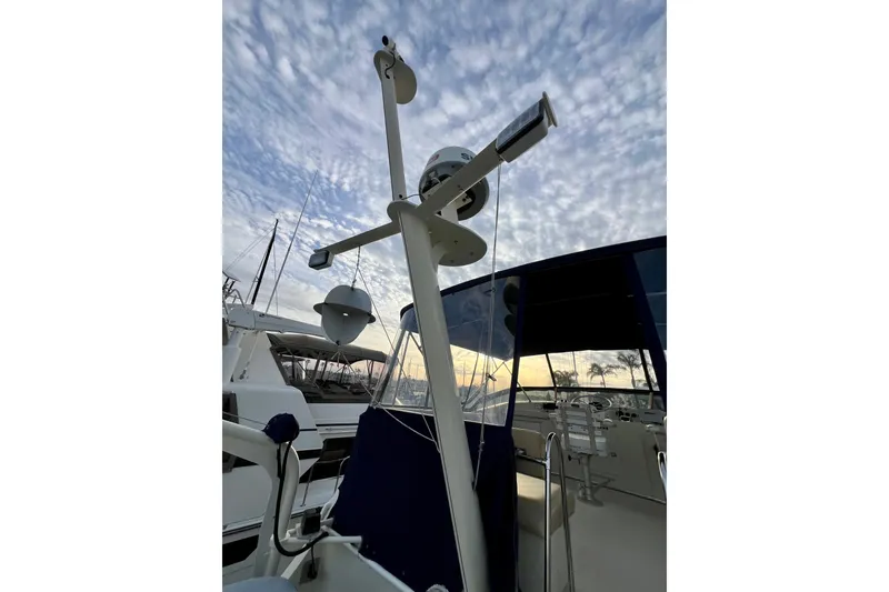 Slide: The Image of 1985 Tollycraft 48 Cockpit Motor Yacht with radar equipment against a cloudy sky. - 24