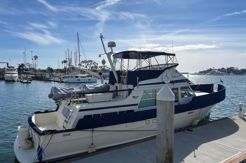 Slide: The Image of 1985 Tollycraft 48 Cockpit Motor Yacht docked at marina under blue sky. - 3