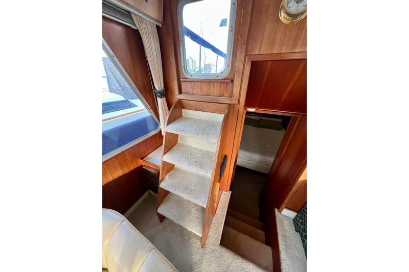 Slide: The Image of Interior view of 1985 Tollycraft 48 Cockpit Motor Yacht with carpeted stairs and wooden paneling. - 37