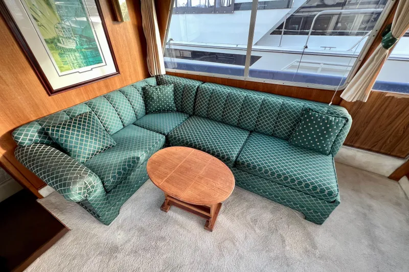 Slide: The Image of Interior of 1985 Tollycraft 48 Cockpit Motor Yacht with green patterned sofa and wooden table. - 39