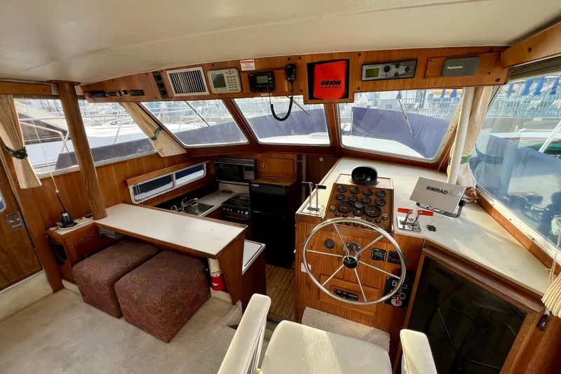 Slide: The Image of 1985 Tollycraft 48 Cockpit Motor Yacht interior with helm, navigation equipment, and seating area. - 41