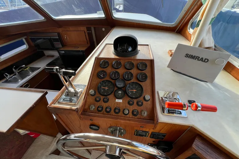 Slide: The Image of 1985 Tollycraft 48 Cockpit Motor Yacht helm with gauges, controls, and Simrad equipment. - 42
