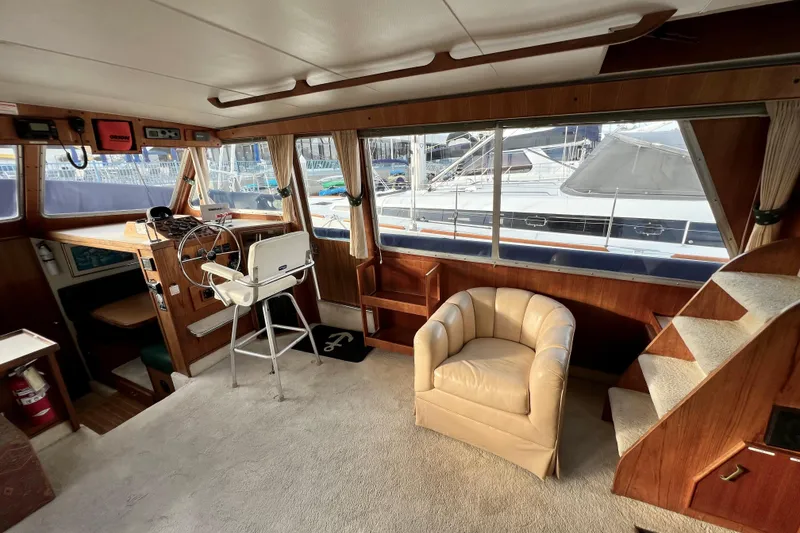 Slide: The Image of 1985 Tollycraft 48 Cockpit Motor Yacht interior with helm, chair, and stairs. - 59