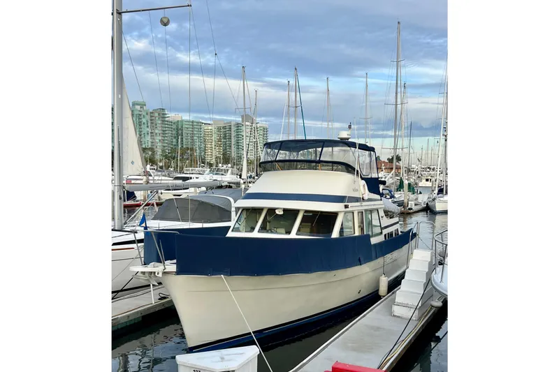Slide: The Image of 1985 Tollycraft 48 Cockpit Motor Yacht docked in marina, surrounded by sailboats. - 6