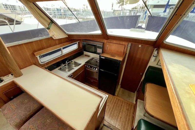 Slide: The Image of 1985 Tollycraft 48 Cockpit Motor Yacht interior with kitchen and dining area. - 60