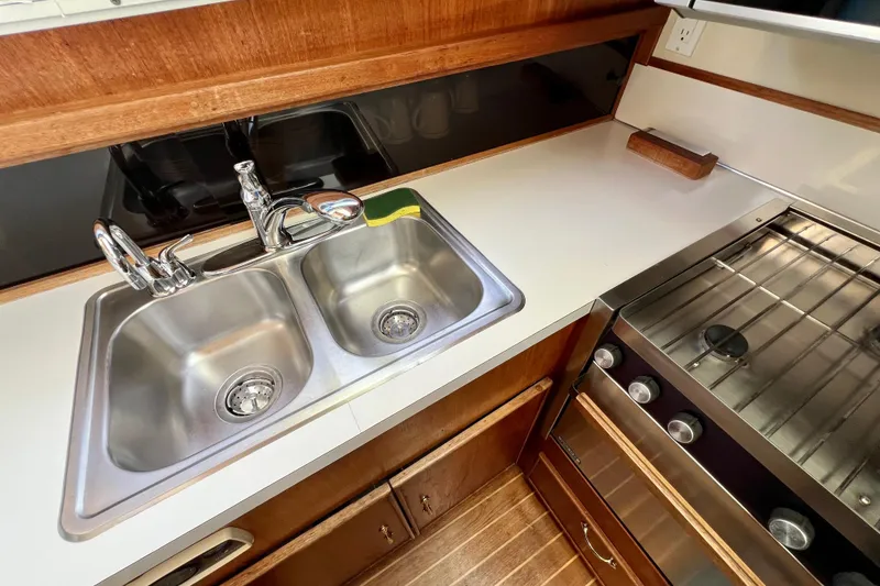 Slide: The Image of 1985 Tollycraft 48 Cockpit Motor Yacht kitchen with stainless steel sink and stove. - 65